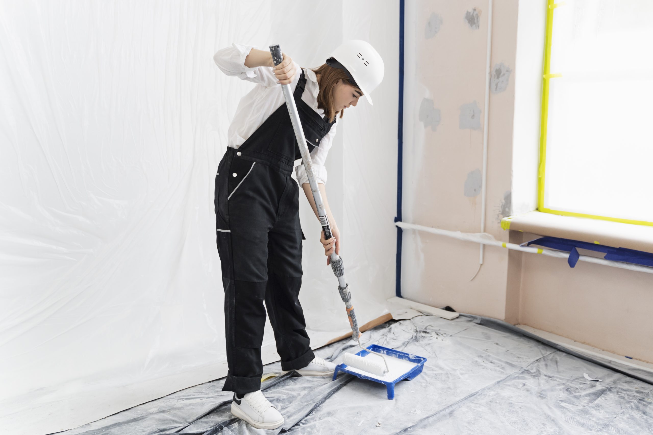 mujer joven pintando la pared de la casa tiro completo scaled